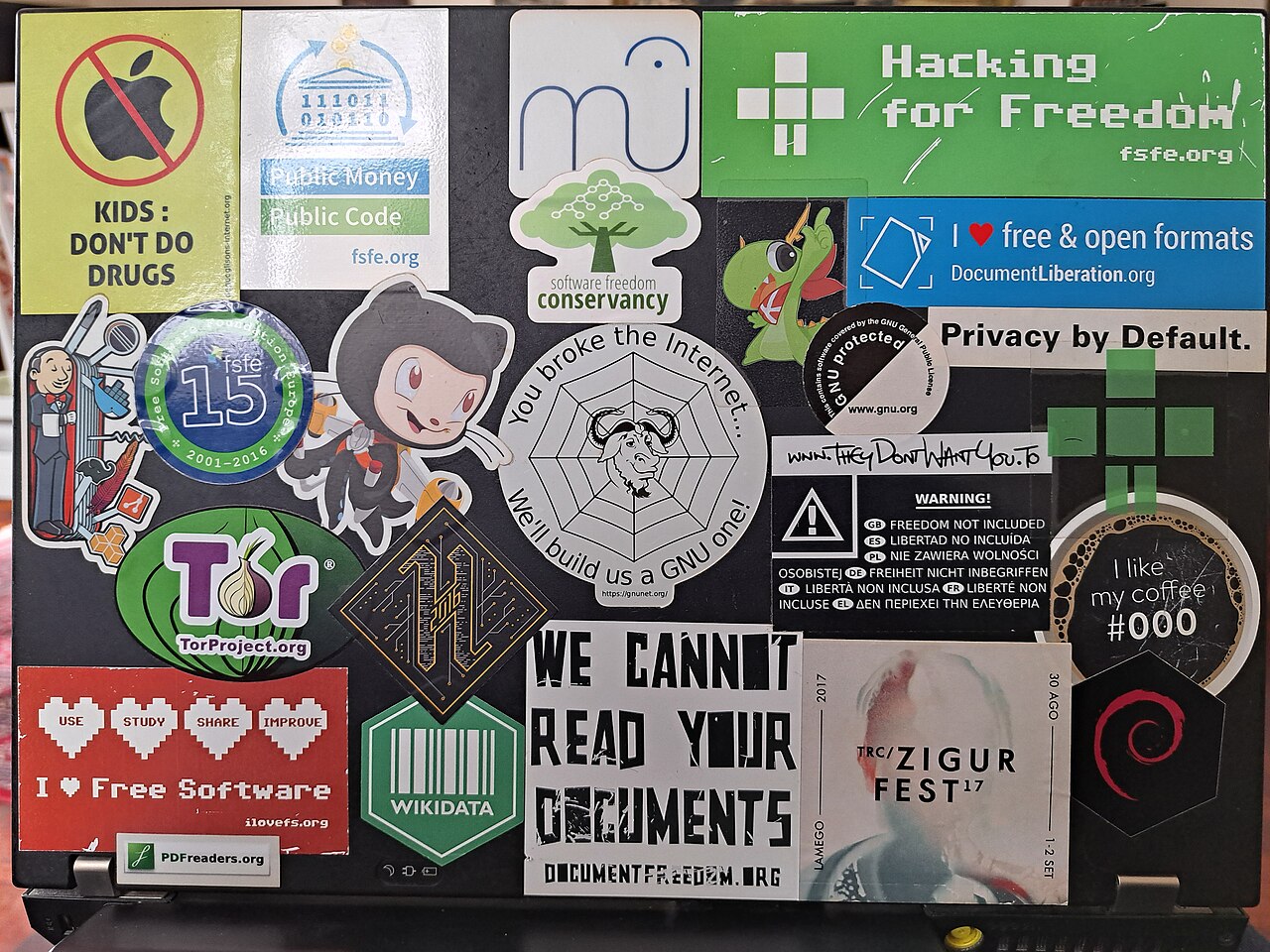 A laptop lid completely covered in free software stickers
