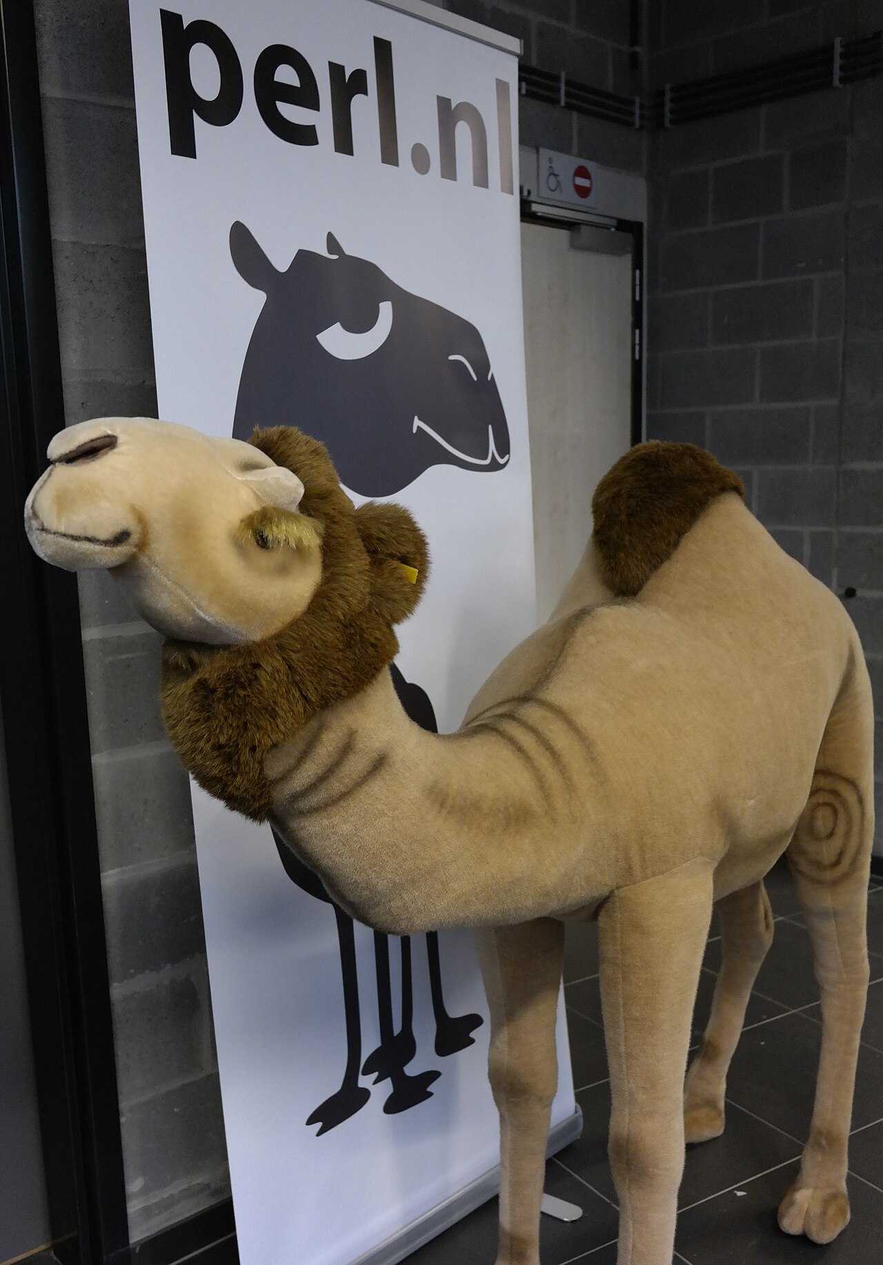 A life-size plush camel beside a perl.nl banner showing a different camel